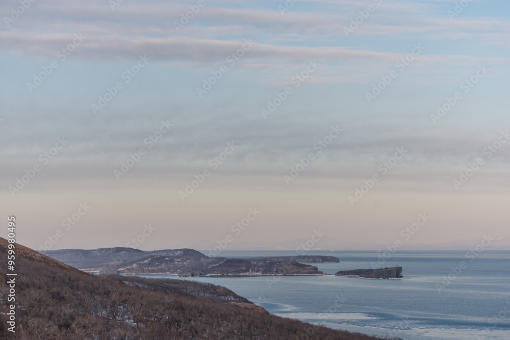 Obraz premium Mystical high cliffs rise above the sea. Harsh winter seascape. Place of power, calm of the elements.