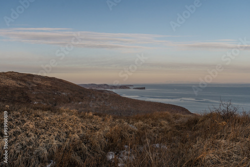 Mystical high cliffs rise above the sea. Harsh winter seascape. Place of power, calm of the elements.