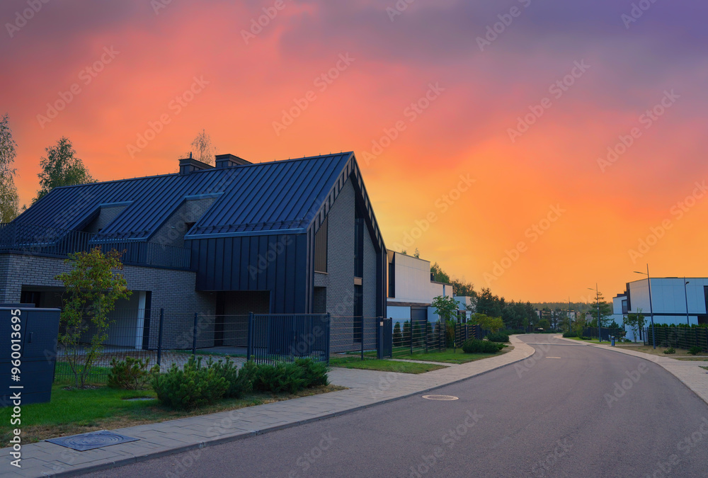 Barn House in village on sunset. Modern luxury house in suburb. Street with Wooden Scandi home. Modern Scandinavian Barnhouse Project. Contemporary barnhouse. Rows of Barn Houses along road village. Barn House in village on sunset. Modern luxury house in suburb. Street with Wooden Scandi home. Modern Scandinavian Barnhouse Project. Contemporary barnhouse. Rows of Barn Houses along road village.