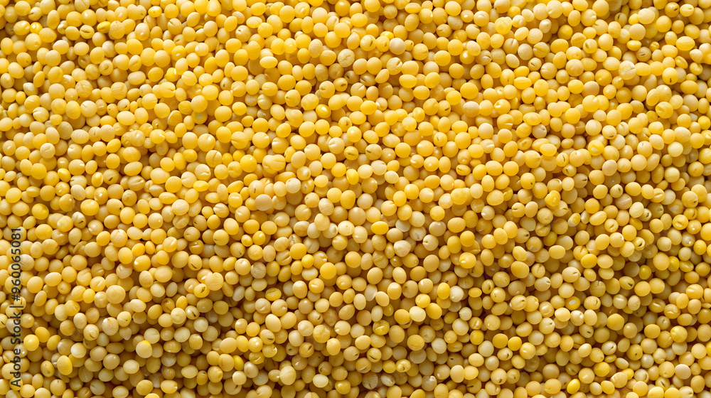 A close-up view of raw millet grains, showcasing their small round shape and yellow color. Ideal for themes related to gluten-free diets, healthy eating, and natural grains. A close-up view of raw millet grains, showcasing their small round shape and yellow color. Ideal for themes related to gluten-free diets, healthy eating, and natural grains.