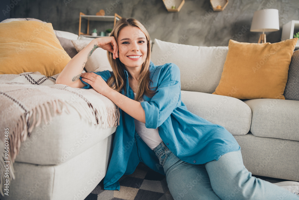 Obraz premium Photo of young blonde hair domestic lady smiling satisfied wearing blue casual shirt indoors loft modern design apartment living room