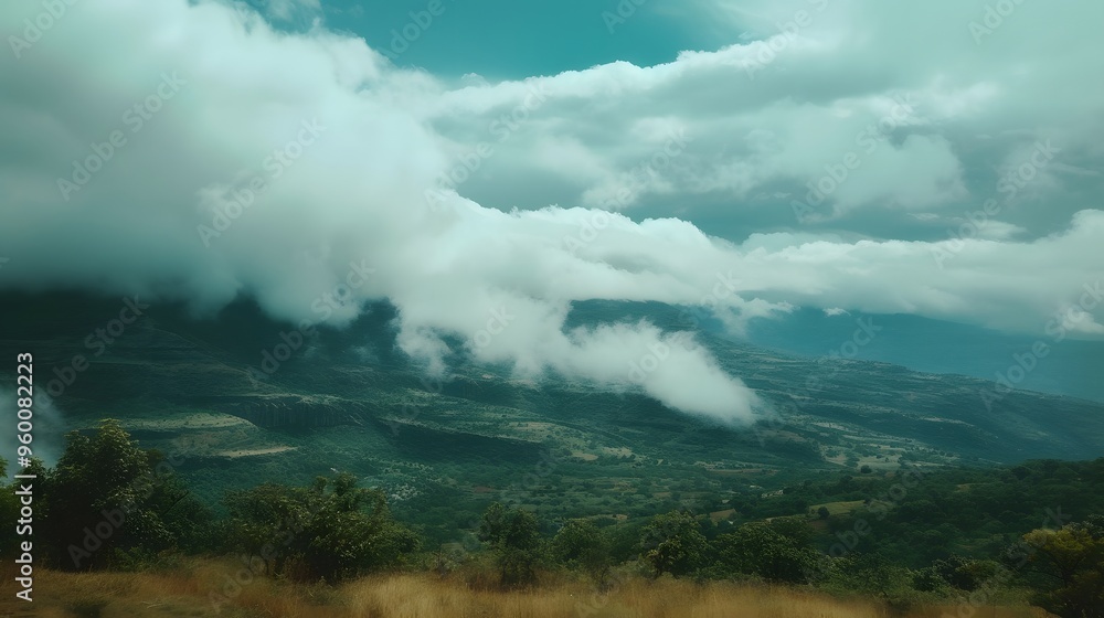 Fototapeta premium A serene landscape with clouds drifting over a mountain range AI generated illustration