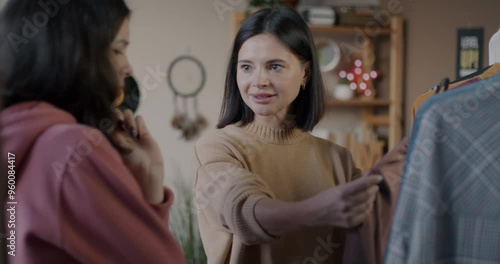 Wallpaper Mural Mother and daughter looking at clothes on hanger choosing outfit discussing style in bedroom at home. Family and fashion concept. Torontodigital.ca