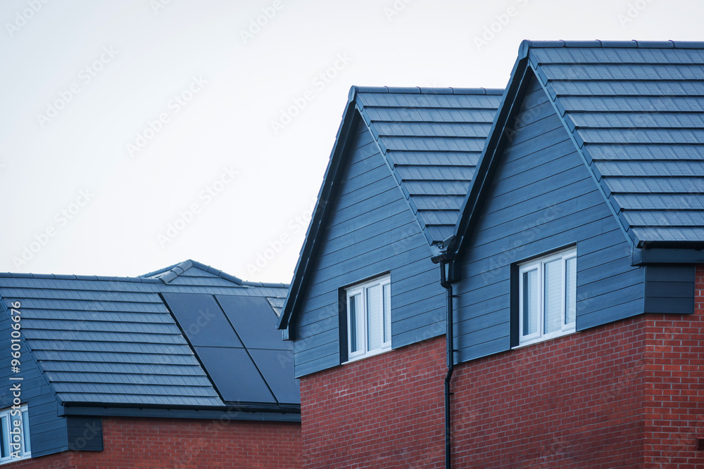 Photovoltaic solar panels on the roof of new built house in england uk. The concept of a sustainable environment, construction. Photovoltaic solar panels on the roof of new built house in england uk. The concept of a sustainable environment, construction.