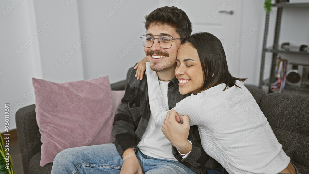 A happy couple cuddles on a couch, exemplifying love and companionship in a cozy living room. A happy couple cuddles on a couch, exemplifying love and companionship in a cozy living room.