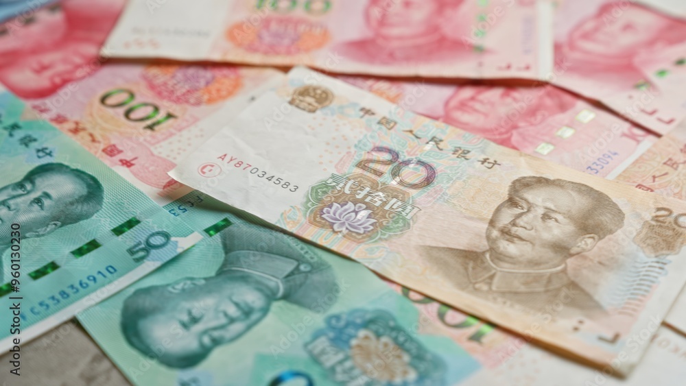 Chinese yuan banknotes scattered closely depict the colorful currency of china for financial and economic themes. Chinese yuan banknotes scattered closely depict the colorful currency of china for financial and economic themes.