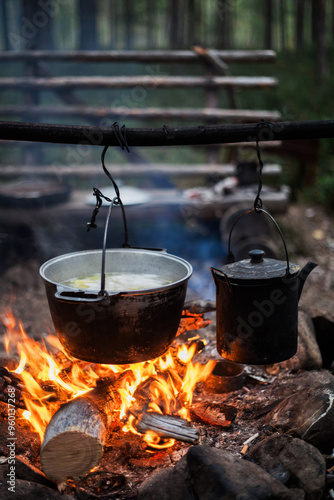 A pot of boiling water is hanging over a fire