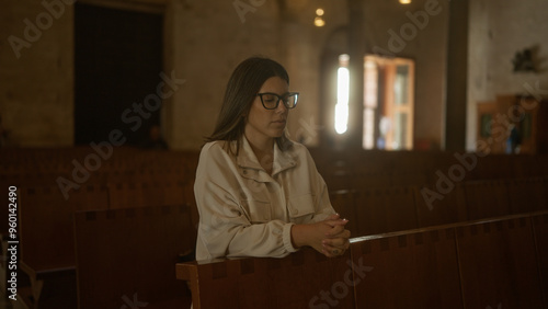 Konstfotografi Young hispanic woman praying in a serene italian church environment, highlighting her beauty and the sacred, peaceful christian atmosphere