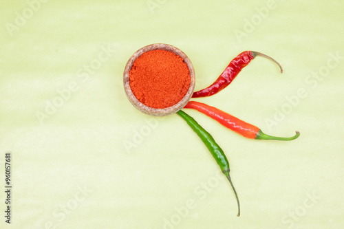 spicy red chilli powder with super chilli background. Top View of Red chilly powder in marbel bowl with red chilly isolated on yellow background. Indian spices, paprika powder or red chilli powder.