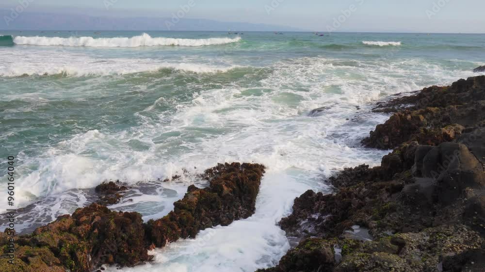 sea wave crashing againts mossy rocks in karang hawu beach, indonesia. beautiful and calm beach atmosphere sea wave crashing againts mossy rocks in karang hawu beach, indonesia. beautiful and calm beach atmosphere