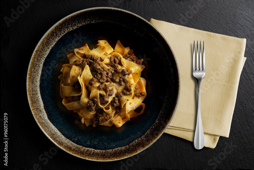Fotografía Dark bowl with pappardelle with wild boar ragout sauce
