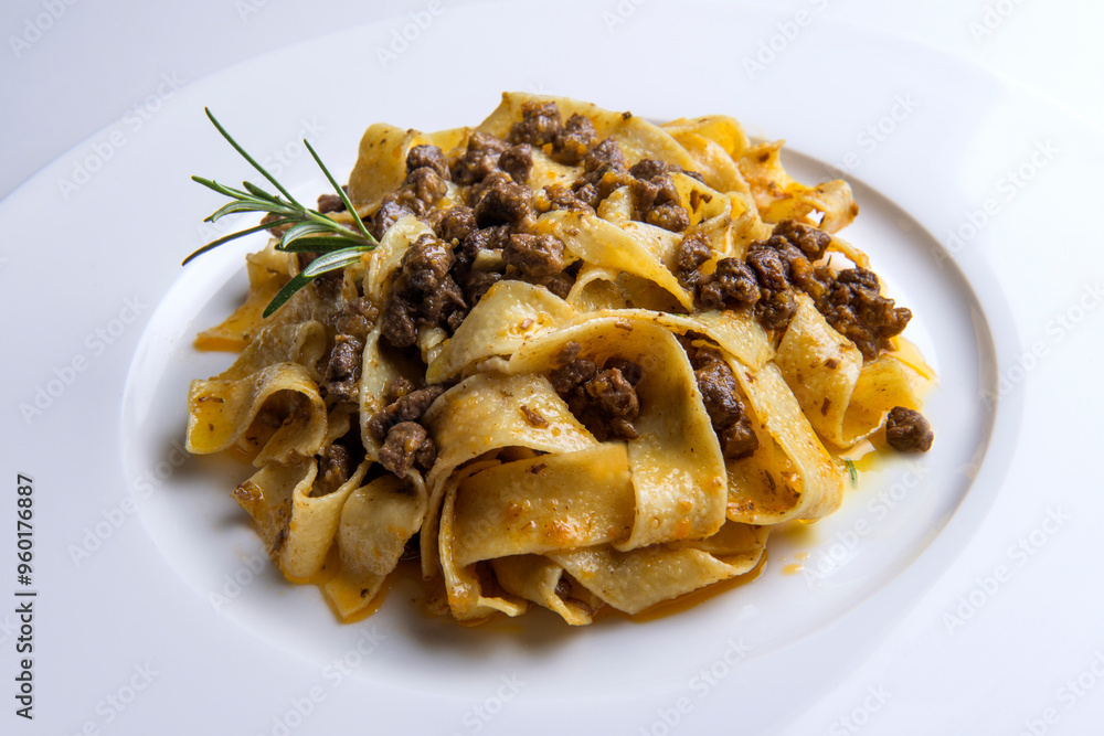 Plate with pappardelle with wild boar ragout sauce and rosemary Plate with pappardelle with wild boar ragout sauce and rosemary