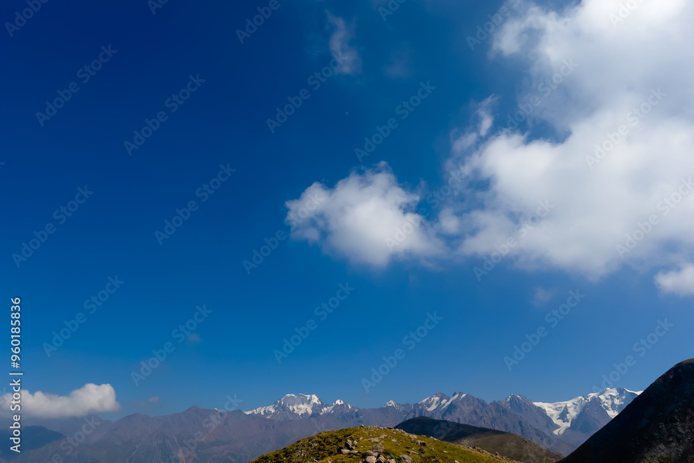 Obraz premium Mountain peaks and blue sky with clouds