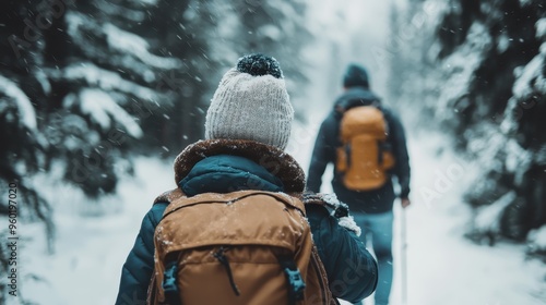 Two adventurers equipped with backpacks and warm clothing make their way through a snowy forest trail, embodying the spirit of exploration and perseverance amid nature's wintry embrace. photo