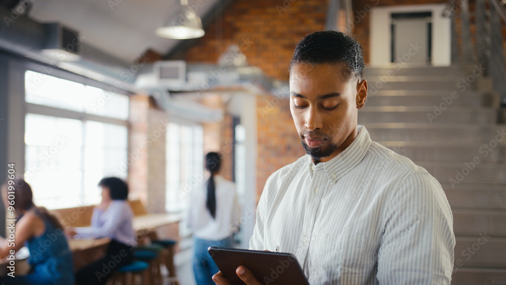 Businessman Using Digital Tablet And Stylus Pen Working In Office With Colleagues In Background Businessman Using Digital Tablet And Stylus Pen Working In Office With Colleagues In Background