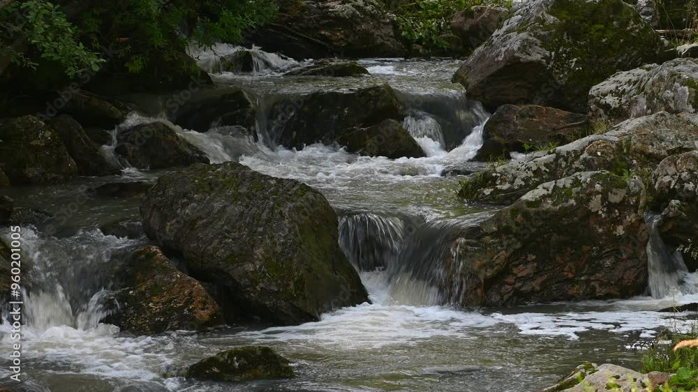 Flowing water cascades over rocks in a serene wilderness river, creating a peaceful and refreshing natural scene Flowing water cascades over rocks in a serene wilderness river, creating a peaceful and refreshing natural scene