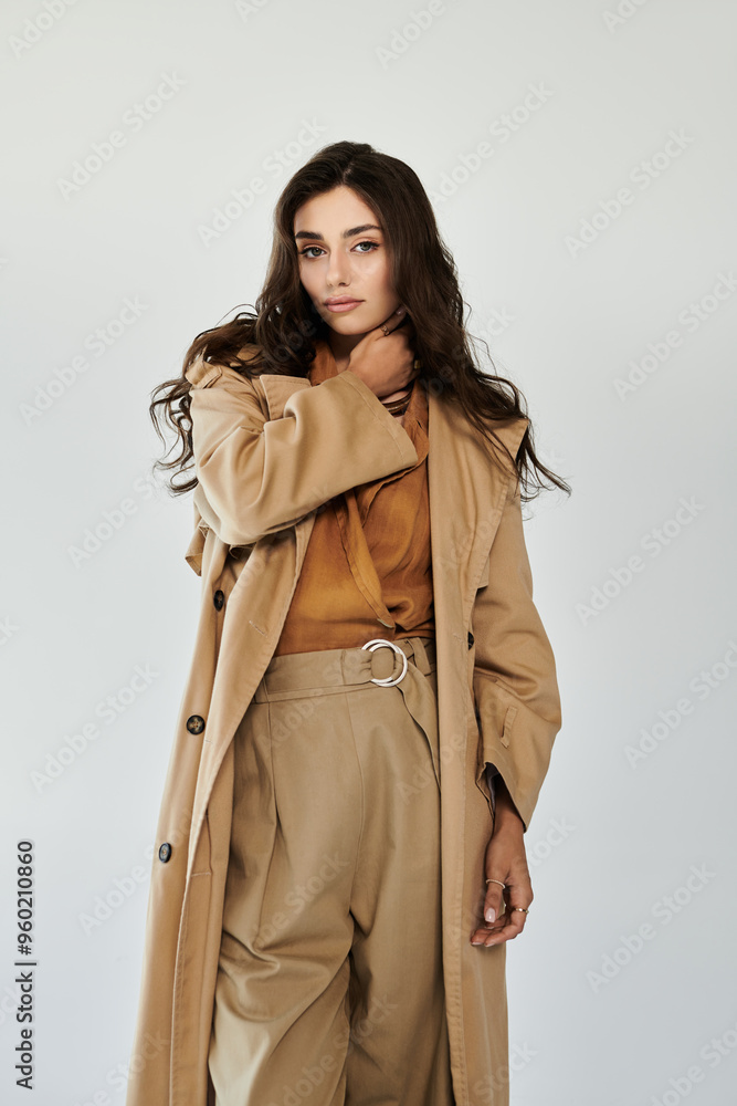 A young woman showcases her autumn style in a chic outfit, exuding confidence and elegance against a minimalistic backdrop. A young woman showcases her autumn style in a chic outfit, exuding confidence and elegance against a minimalistic backdrop.