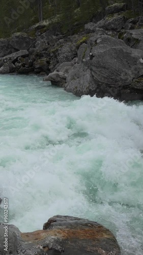 Vertical Wild water stream with white foam slow motion in Norway photo