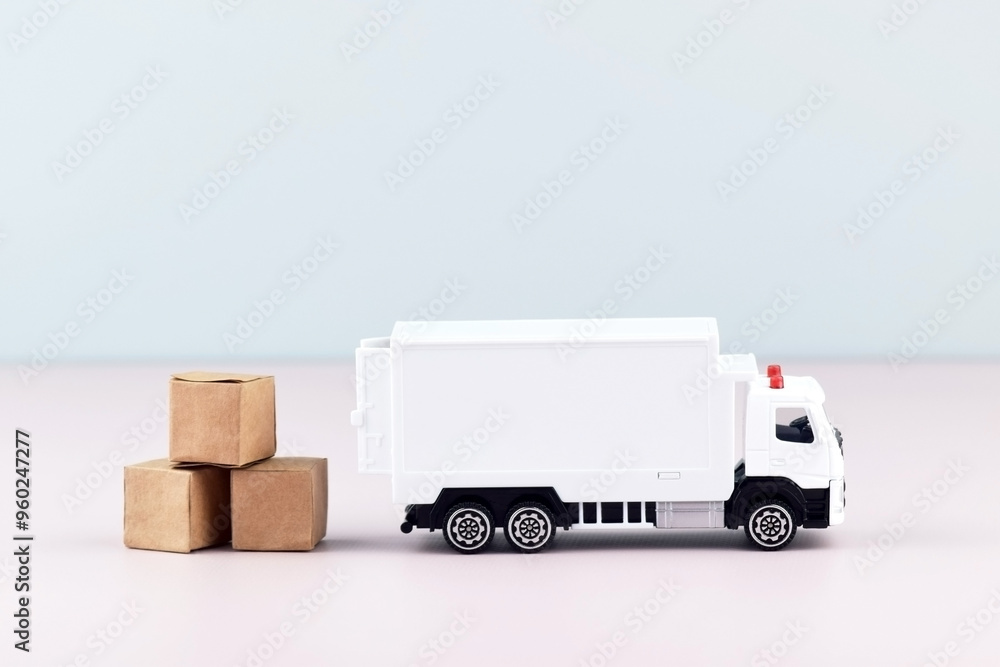 White toy truck with boxes on a light background, space for text. White toy truck with boxes on a light background, space for text.