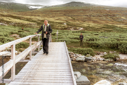 Young hiker with camera mountains landscape Rondane National Park Norway. photo