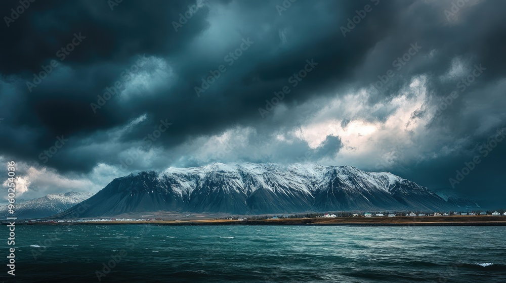 Reykjavik's Esjan mountain range viewed from across the bay with a dramatic sky overhead. Reykjavik's Esjan mountain range viewed from across the bay with a dramatic sky overhead.