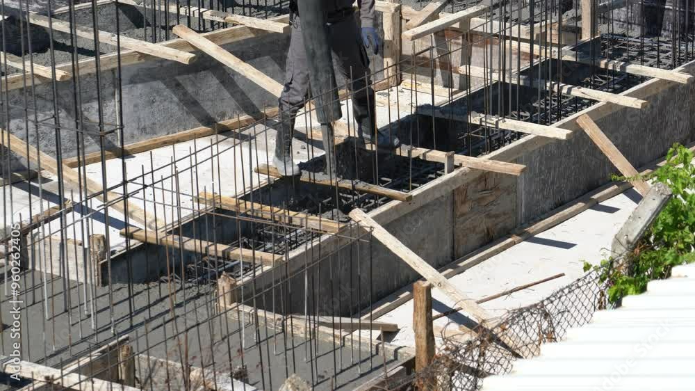 Concreting of reinforced concrete slab with pump concrete mixer. Workers are pouring cement mortar on the foundation and rebar. Concreting of reinforced concrete slab with pump concrete mixer. Workers are pouring cement mortar on the foundation and rebar.