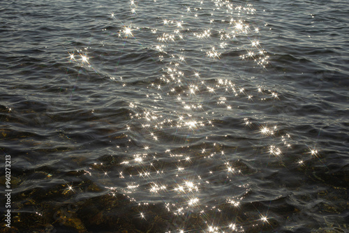 Fototapeta Naklejka Na Ścianę i Meble -  reflection sparkles on tiny ripples of sea water wave background, top view.