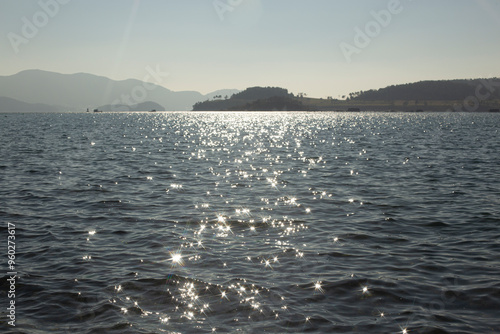 reflection sparkles on tiny ripples of sea water wave background, top view.