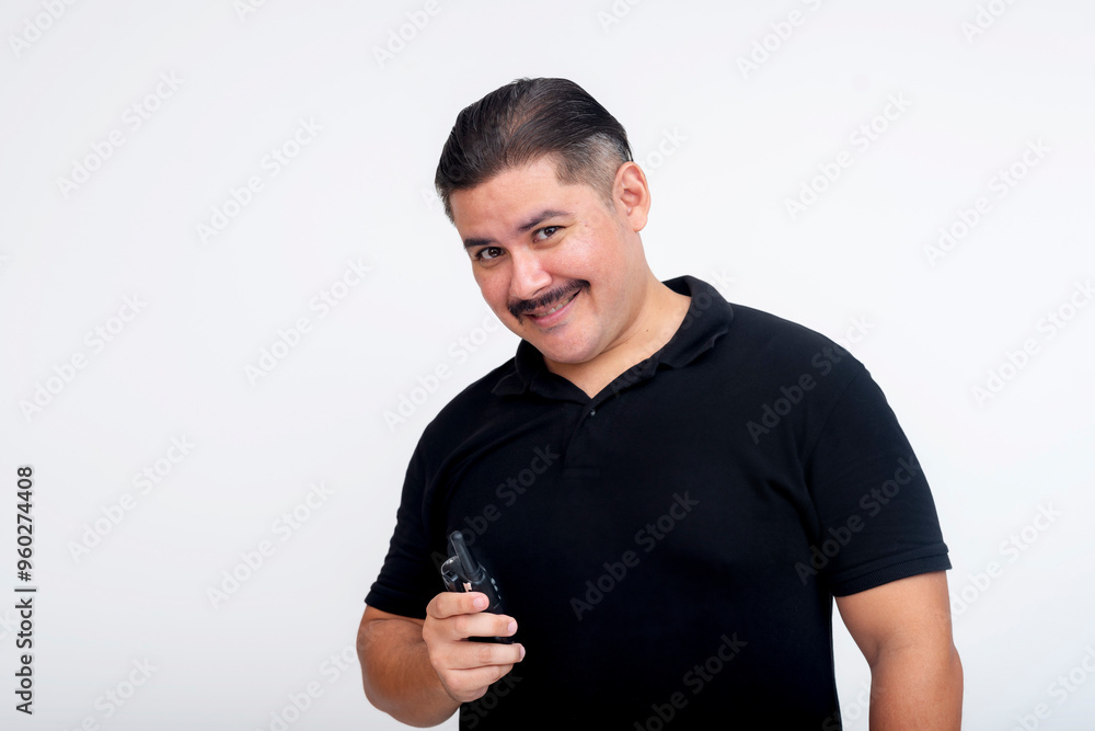 A middle-aged man in a black t-shirt smiling while holding a two-way radio. Isolated on a white background.