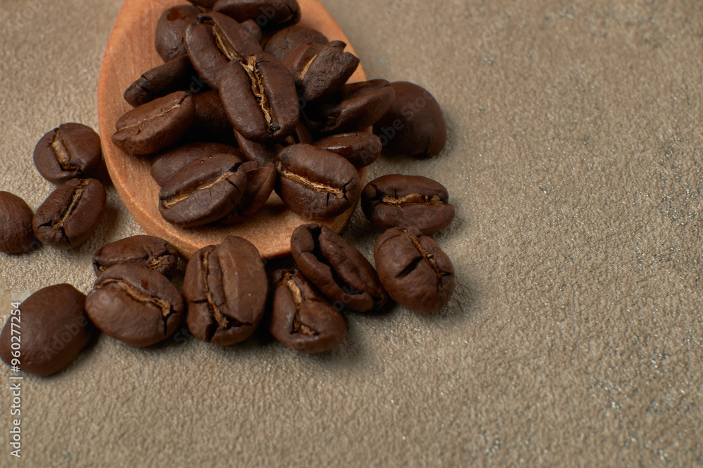 Roasted coffee beans on a wooden spoon Roasted coffee beans on a wooden spoon