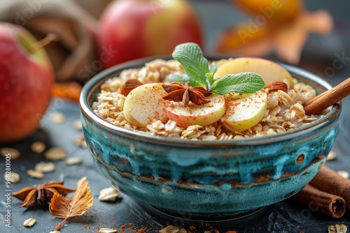 A bowl of oatmeal topped with fresh apple slices, cinnamon, and mint leaves, creating a cozy autumn breakfast setting.