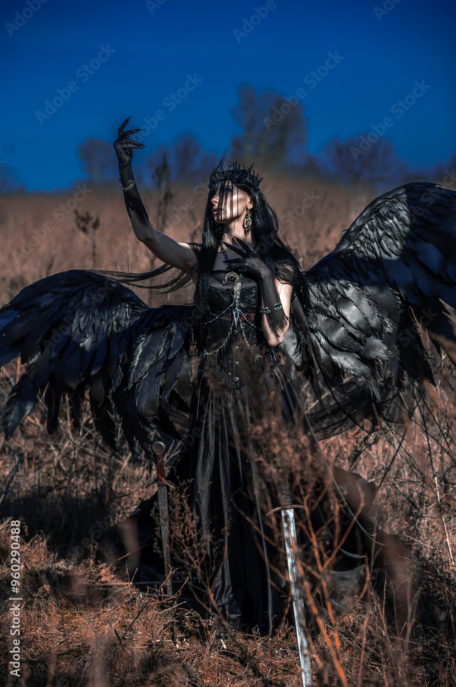 Goddess of death with black wings on a dried field Goddess of death with black wings on a dried field