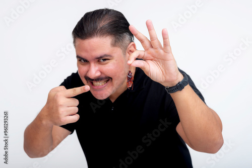 A mischievous middle aged man deviously grinning while holding a fake cockroach for a prank. Set against a white background. photo