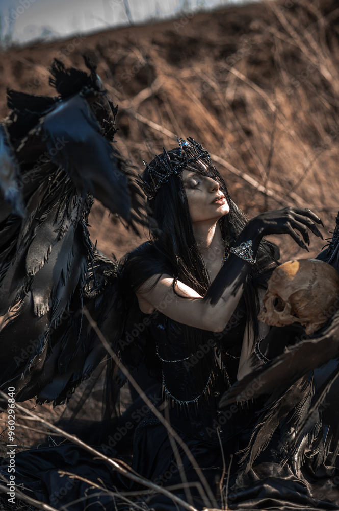 Goddess of death with black wings on a dried field Goddess of death with black wings on a dried field