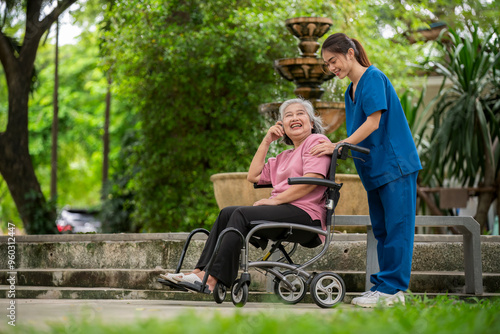 Elderly woman seated in a wheelchair with young caregiver or healthcare worker is standing behind reflects care, compassion, and a supportive relationship the caregiver and elder healthy concept.