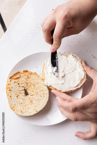 hands with bagel and cream cheese photo