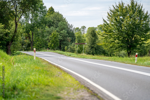 Fototapeta Naklejka Na Ścianę i Meble -  An asphalt road going through a forest in Masuria