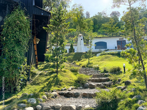 Quadro su tela Natural scenery of outdoor vintage rural barnyard warehouse, with pine trees, and pebble staircase footpath at outdoor garden, resembling rural countryside European garden