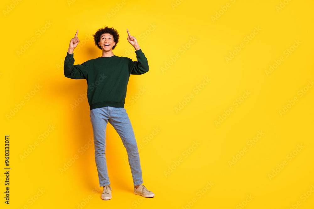 Full body portrait of nice young man direct fingers up empty space wear sweater isolated on yellow color background Full body portrait of nice young man direct fingers up empty space wear sweater isolated on yellow color background