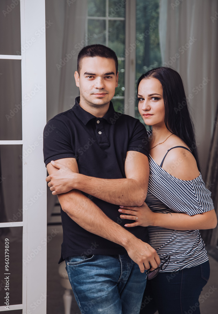 Young couple posing together indoors in a cozy and intimate setting. A young couple stands closely together at home Young couple posing together indoors in a cozy and intimate setting. A young couple stands closely together at home