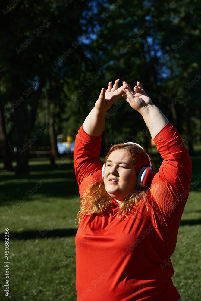 A vibrant plus size woman enjoys stretching outdoors amid nature. A vibrant plus size woman enjoys stretching outdoors amid nature.