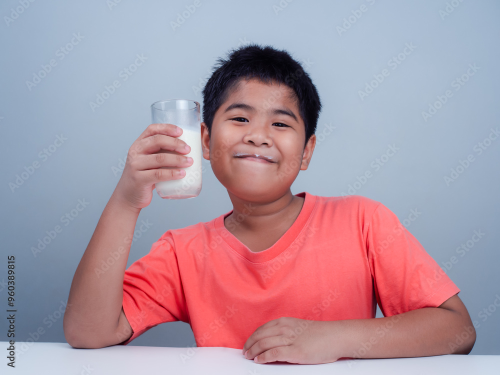 Concept of happy good nutrition, Portrait of a little young handsome kid boy in pink t-shirt, Holding a glass of milk on white background, Smiling of Asian boy with a glass of milk. Concept of happy good nutrition, Portrait of a little young handsome kid boy in pink t-shirt, Holding a glass of milk on white background, Smiling of Asian boy with a glass of milk.