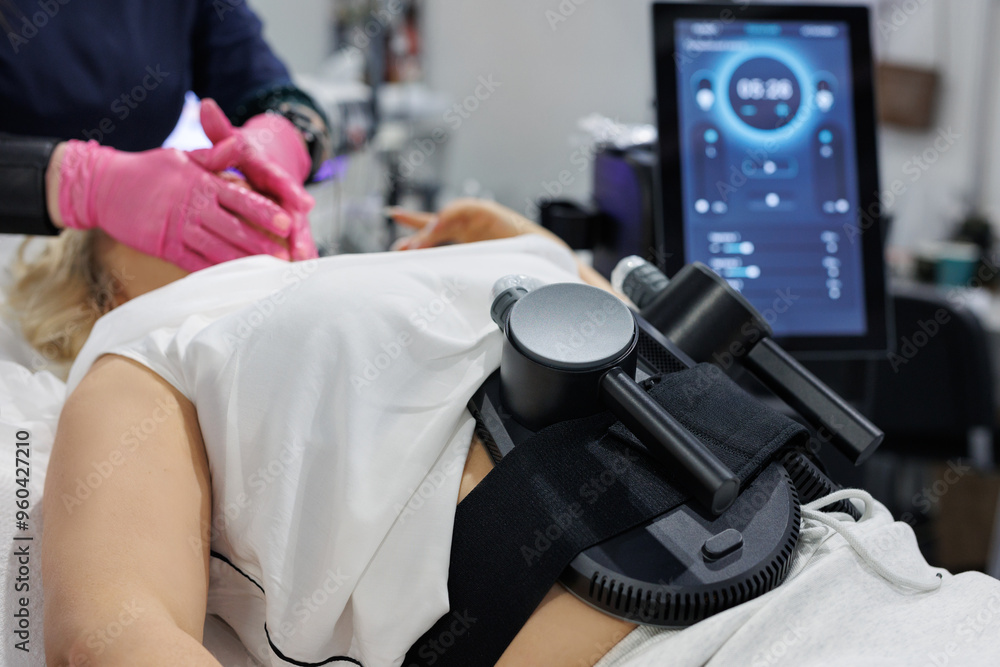 A woman is undergoing treatment to burn fat, build muscle and eliminate cellulite. A woman is undergoing treatment to burn fat, build muscle and eliminate cellulite.