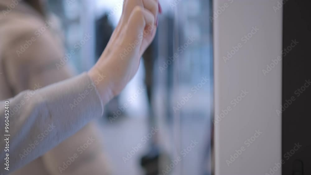 Close-up of a person using a touchscreen device in a public setting, highlighting engagement with technology. Close-up of a person using a touchscreen device in a public setting, highlighting engagement with technology.