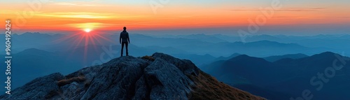 A solitary traveler stands atop a mountain during a breathtaking sunset, capturing the essence of adventure and tranquility.