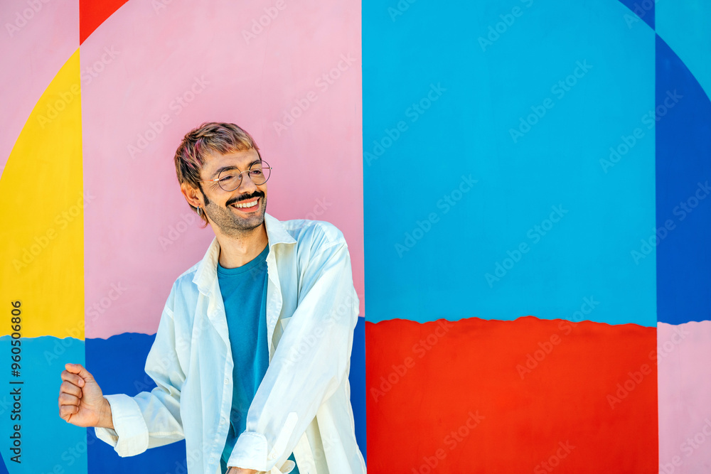 © ADDICTIVE STOCK - Joyful man posing against a vibrant multicolored backdrop