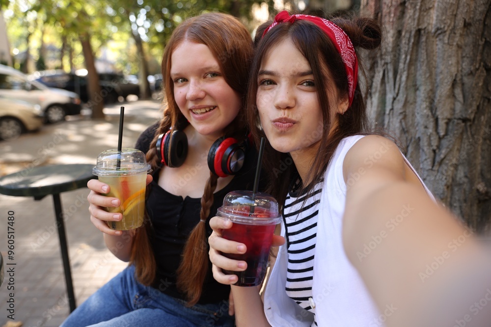 Happy teenage friends taking selfie in outdoor cafe Happy teenage friends taking selfie in outdoor cafe