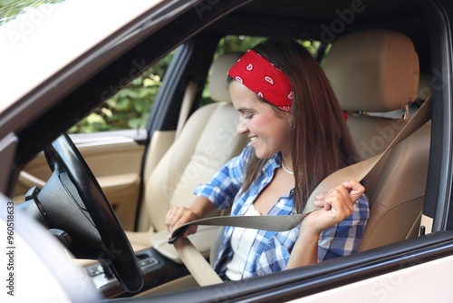 Smiling woman fastening safety seat inside car photo