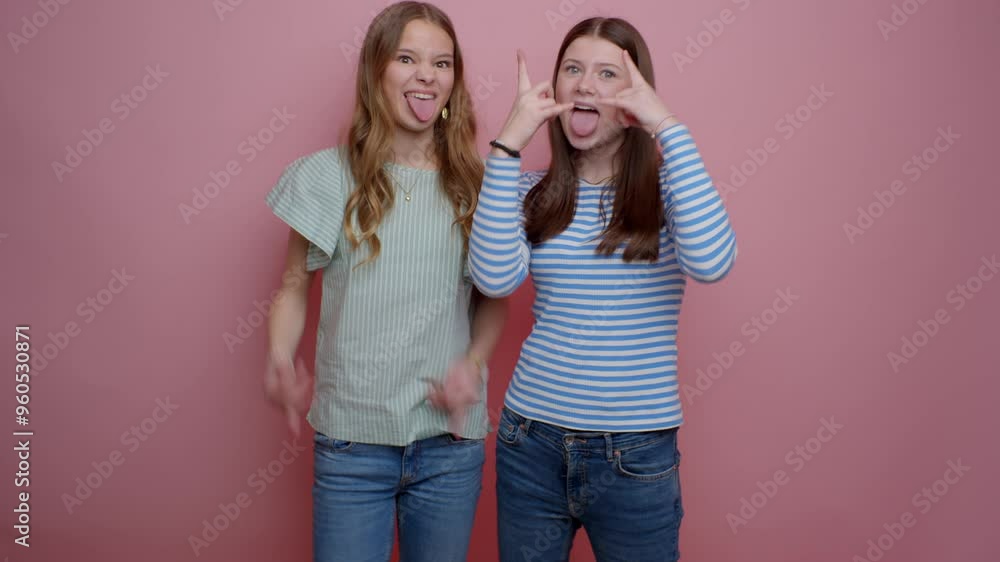 Two Girls Doing Wacky Poses Against A Pink Background Two Girls Doing Wacky Poses Against A Pink Background