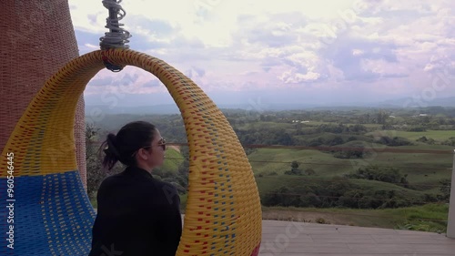 mujer contempla el eje cafetero desde una silla